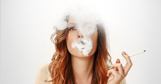 woman blowing smoke from a cigarette