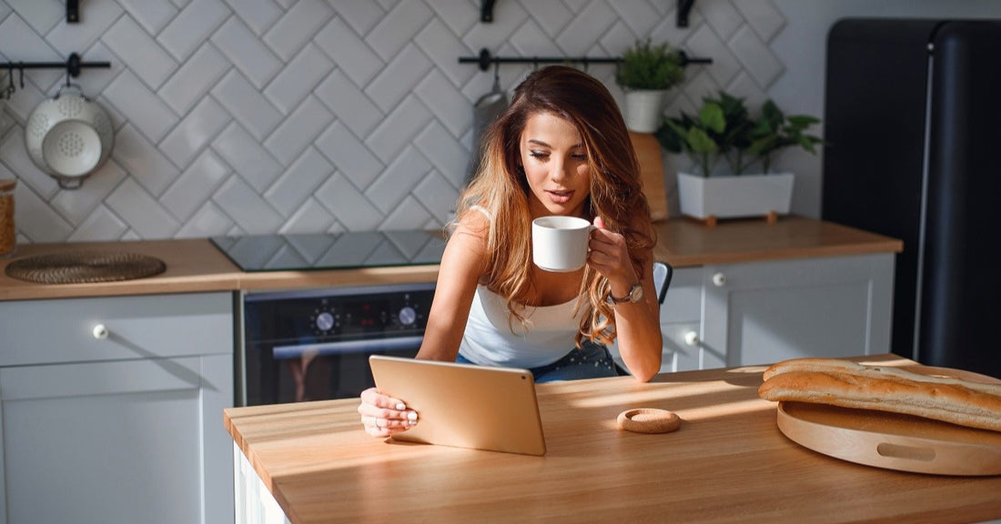 attractive young woman in the kitchen drinking coffee